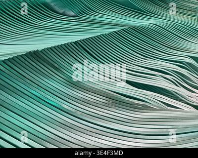 Sheets of glass stacked together in layers of repeating shapes form a shape similar to ocean waves. Stock Photo