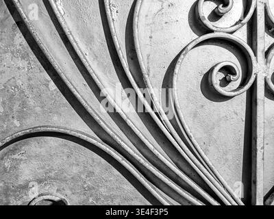 Sunlight provides contrast in lights and shadows from the ironwork relief pattern on a door in San Francisco. Stock Photo