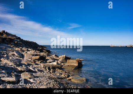 Rocky coastline of the Baltic Sea under blue sky in Tallinn Estonia Stock Photo