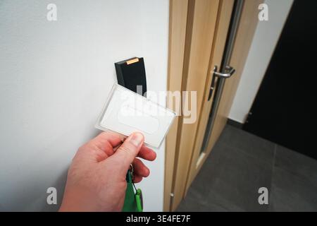 Office Access Card Entry Security Reader, hand holding keycard near electronic door scanner, contactless authorization, workplace protection, corporat Stock Photo