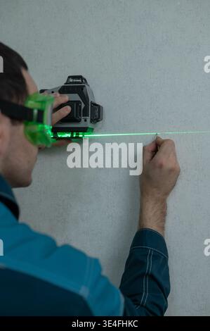 A man measures distance with a laser level.  Stock Photo