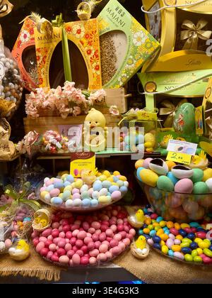 Verona, Italia - March 24, 2026: Colorful Easter display featuring decorative eggs, a chick figurine, and assorted candies arranged on a festive table Stock Photo