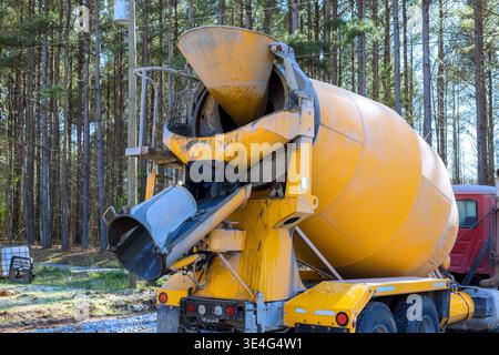 Cement mixer truck is positioned at construction site workers prepare for concrete pouring. Stock Photo