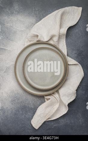 Food, Empty grey plates and linen napkin on grey concrete or stone table. Cooking background. Rustic style. Selective focus. Top view, copy space Stock Photo