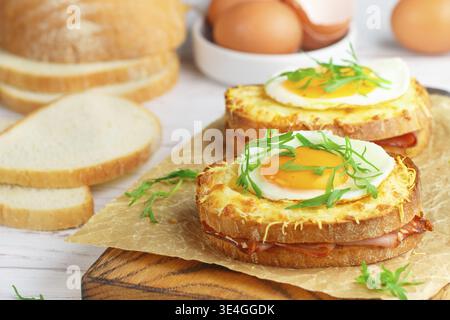 Food, Sandwich white bread with ham or bacon, mustard, cheese, Bechamel sauce, watercress and eggs. CROQUE MADAME. traditional French cuisine. Selecti Stock Photo