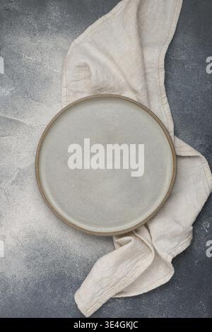 Food, Empty grey plate and linen napkin on grey concrete or stone table. Cooking background. Rustic style. Selective focus. Top view, copy space Stock Photo