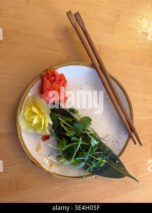 empty plate with ginger, microgreens, flower, chopsticks on wood table concept Stock Photo
