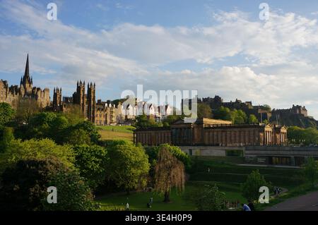 View of Edinburgh Old Town and National Galleries of Scotland. People relaxing at the park Stock Photo