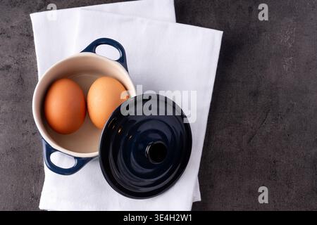 Two eggs with a crock pot in a kitchen Stock Photo