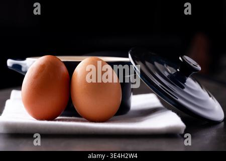 Two eggs with a crock pot in a kitchen Stock Photo