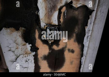 Close up off a light switch ripped out in an abandoned house, a burned wall, moldy with peeling paint, urbex scenery, disturbing mood Stock Photo