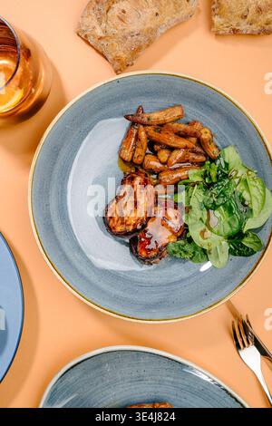 Gourmet pork tenderloin medallions wrapped in crispy bacon, served with baby corn and fresh spinach, finished with demi-glace or balsamic glaze, garli Stock Photo