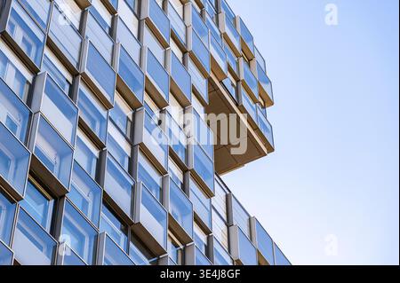 Close-up view of a modern glass building facade, featuring repeating geometric window panels and clean lines, showing contemporary architecture detail Stock Photo