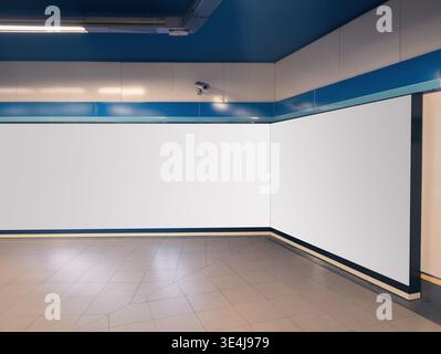 Modern indoor setting with a blank billboard on a tiled floor and blue walls, ready for advertisement or promotional mockup design, in a shopping mall Stock Photo