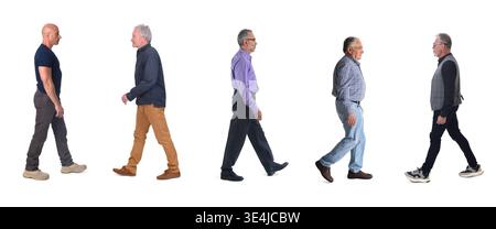 side view of a group of mature men walking on a white background Stock Photo