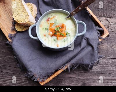 A delicious bowl of creamy hot carrot soup with bread Stock Photo