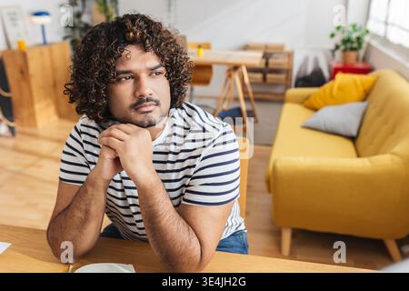 Young Indian man serious while studying at home Stock Photo