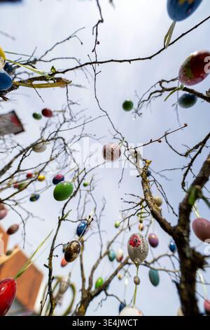 Bieberbach, Germany. 28th Mar, 2026. Numerous hand-painted eggs hang from an Easter bush next to the Easter fountain in Bieberbach. The Easter fountain in Franconian Switzerland is one of the largest in the world. In 2000, it made it into the Guinness Book of Records with exactly 11,108 hand-painted eggshells. This year it is decorated with around 10,000 eggs. Every year at Easter, the fountains in Franconia are decorated with colorful eggs and other Easter motifs, attracting numerous onlookers. Credit: Pia Bayer/dpa/Ģ����ý Live News Stock Photo