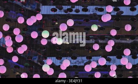 Pink glowing spheres creating abstract light art installation at night Stock Photo