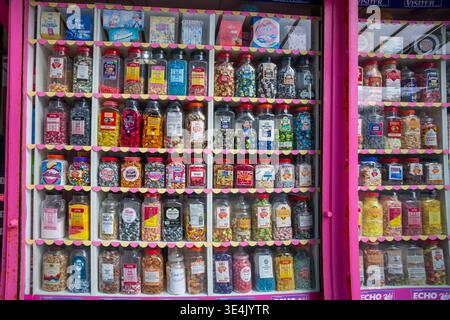 Colorful jars filled with delightful candies line the sweetshop shelves, inviting visitors to indulge in a variety of sugary treats. The cheerful disp Stock Photo