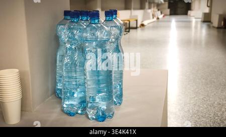 Several clear plastic water bottles on table, filled with clean drinking water, bottles lined up, hydration and refreshment concept, closeup detail, m Stock Photo