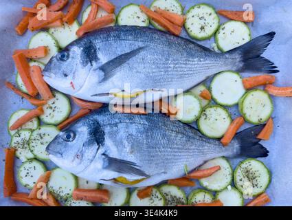 Fresh gilt head bream with lemon and vegetables cooking preparation Stock Photo