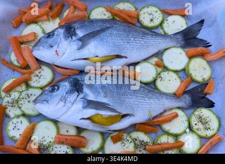 Fresh gilt head bream with lemon and vegetables cooking preparation Stock Photo