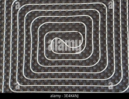 Radiant floor heating layout with pipes installed on thermal insulation Stock Photo