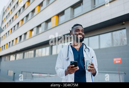 Male Nurse Using Smartphone On Coffee Break Stock Photo