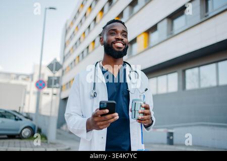 Male Nurse Using Smartphone On Coffee Break Stock Photo