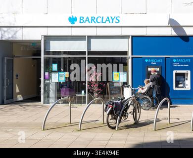 People using ATM cash machine at branch of Barclays Bank, Lowestoft town centre, Suffolk, England, UK Stock Photo