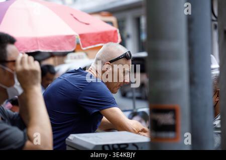 BANGKOK, THAILAND-MAR 15, 2026: Senior man resting while exploring an outdoor market, side profile, at Yaowarat Stock Photo
