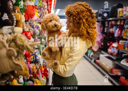 Young woman with poodle in pet shop Stock Photo