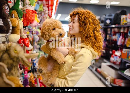 Young woman with poodle in pet shop Stock Photo
