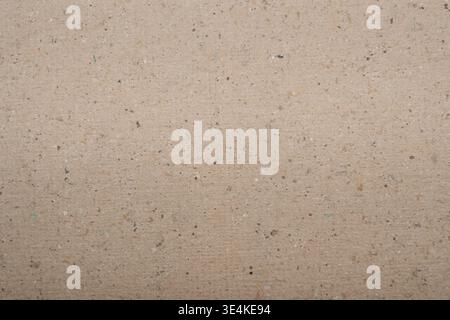 Textured brown paper background featuring speckles and natural fibers, providing a neutral and organic appearance suitable for various design and craf Stock Photo
