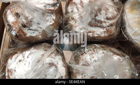 Easter cakes in clear packaging with bright sprinkles. Preparing for Easter. Festive baked goods at the store. Close-up of packaged Easter cupcakes. Stock Photo