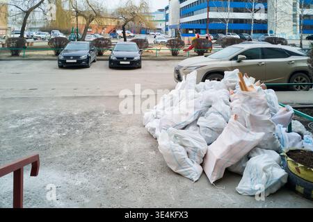 Sacks of rubble and debris stacked on a pavement. Ideal for waste management, recycling, and urban development themes Stock Photo
