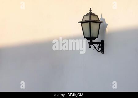 Vintage street lamp on white wall with shadow Stock Photo