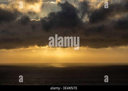 Storm clouds over the sea at sunset, off the Cornish coast Stock Photo