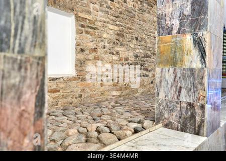 Architectural interior photograph showcasing the juxtaposition of historic and contemporary design elements. The scene features an exposed weathered Stock Photo