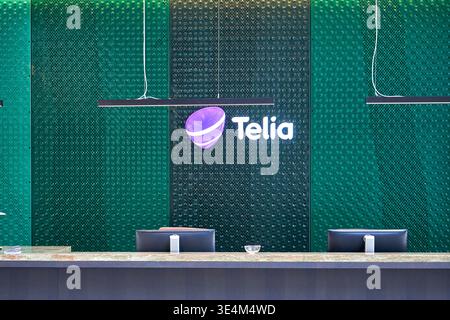 Modern corporate reception or service counter interior featuring Telia telecommunications branding. The image shows a sleek counter with two computer Stock Photo