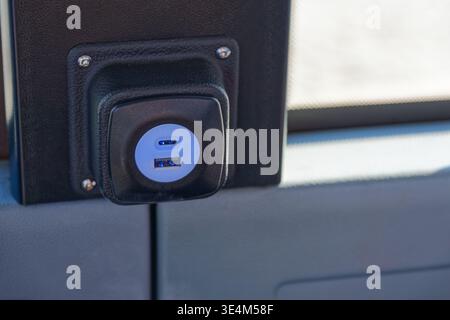 Dual USB charging ports mounted on a vehicle interior panel provide convenient power access for electronic devices during travel or daily use. Stock Photo