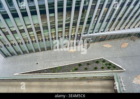 Aerial view of the glass facade of a modern office building reflecting ...