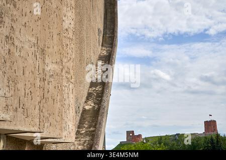 A close-up view of a weathered concrete architectural structure with a curved edge dominates the left foreground, showcasing rough texture and Stock Photo