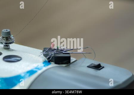 A Close-Up View of Colorful Sewing Pins and Threads on a Sewing Machine for Crafting and Tailoring Projects Stock Photo