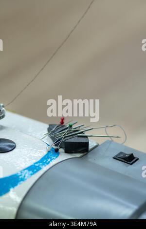 A Close-Up View of a Sewing Machine with Needles and Pins for Creative Crafting and Tailoring Projects Stock Photo
