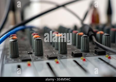 Close-Up View of an Audio Mixing Console with Focus on Knobs and Cables for Sound Engineering Applications Stock Photo