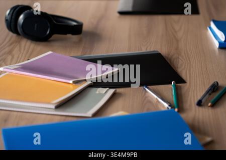 A Vibrant Workspace Featuring Stationery, Notebooks, and Headphones for Creative Inspiration and Productivity Stock Photo