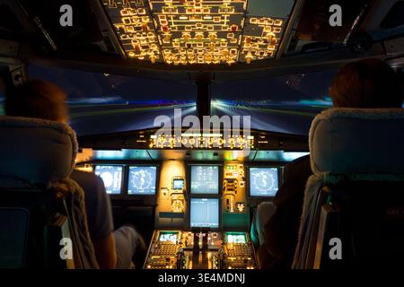 Commercial aircraft cockpit view during night takeoff roll with illuminated runway lights Stock Photo