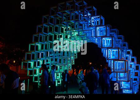 A large-scale light installation at a night festival, featuring a tunnel-like structure composed of interconnected cube frames. The installation is Stock Photo